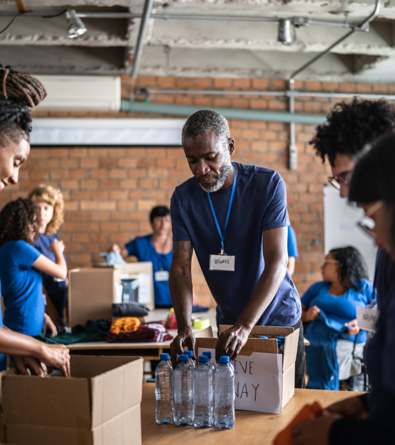 A group of people standing around boxes and bottles.