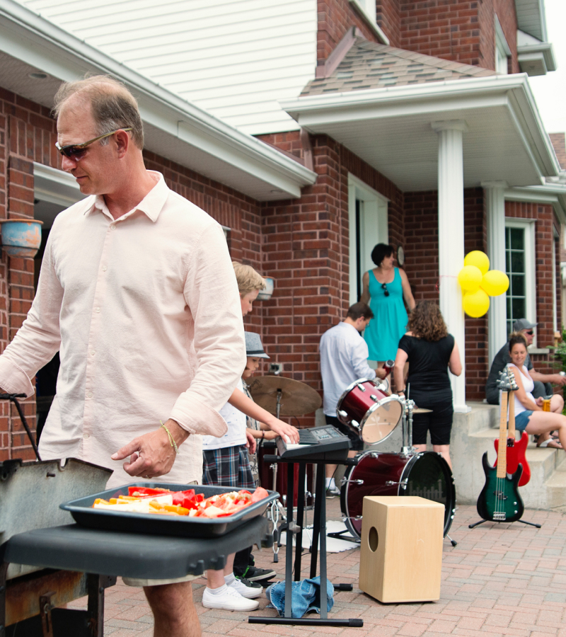 A man standing next to an outdoor grill.