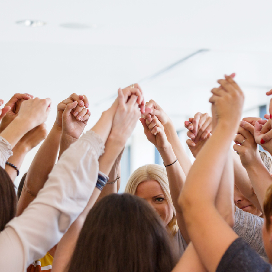 A group of people holding their hands up in the air.