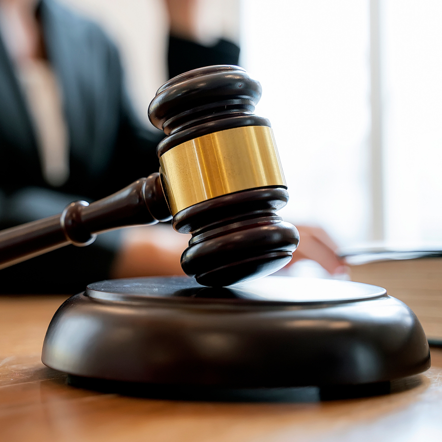 A judge 's gavel on top of a wooden table.