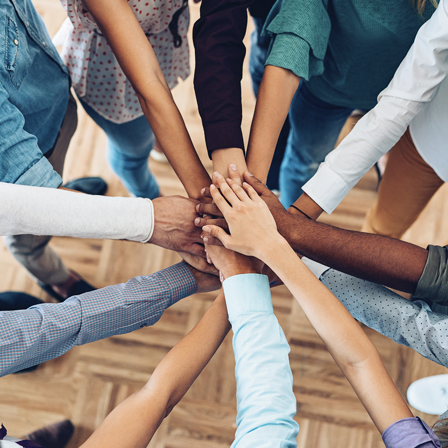 A group of people standing next to each other with their hands in the air.