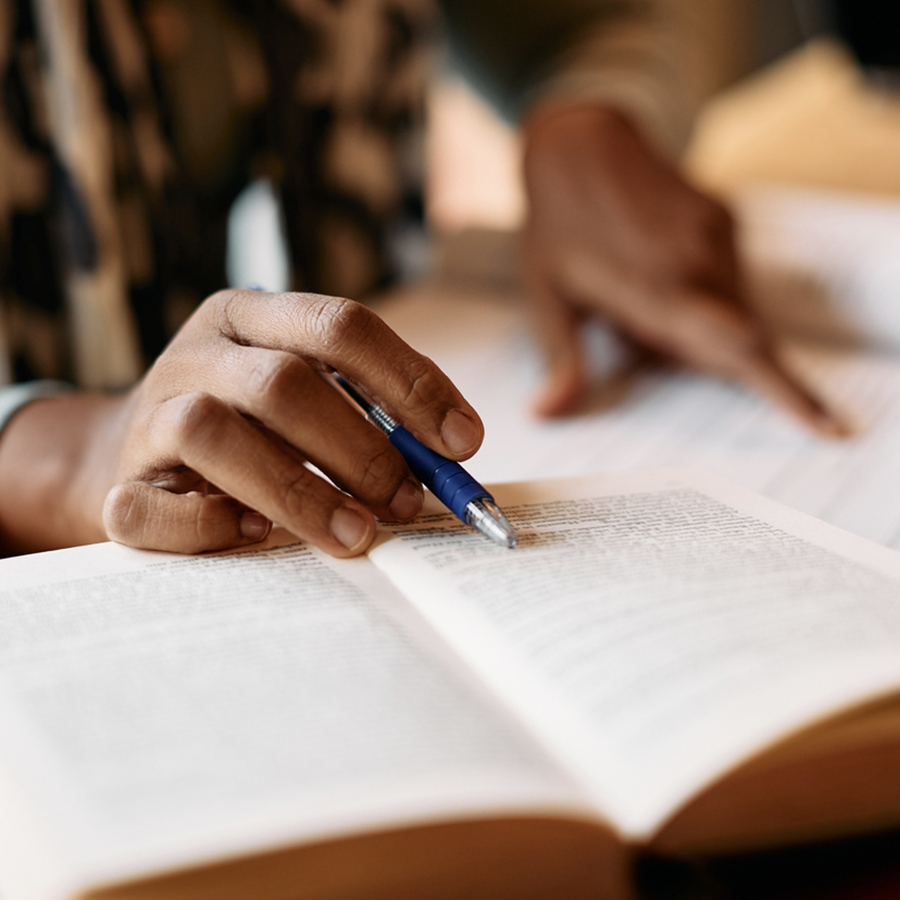 A person writing on an open book