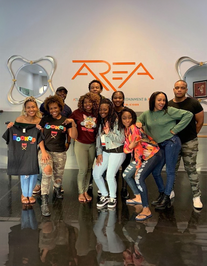 A group of people posing for the camera in front of an area sign.